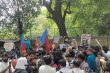 Students and activists protest at Jantar Mantar with banners and flags against the NEET 2026 paper leak and re-exam announcement.