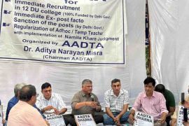 Teachers and AADTA members sit during a protest demonstration under a banner highlighting demands for recruitment and regularisation of ad hoc teachers in Delhi University colleges.