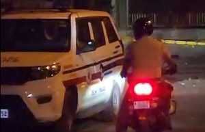 A Delhi Police vehicle and a motorcyclist on a road near Zakir Husain Delhi College at night after a police encounter.