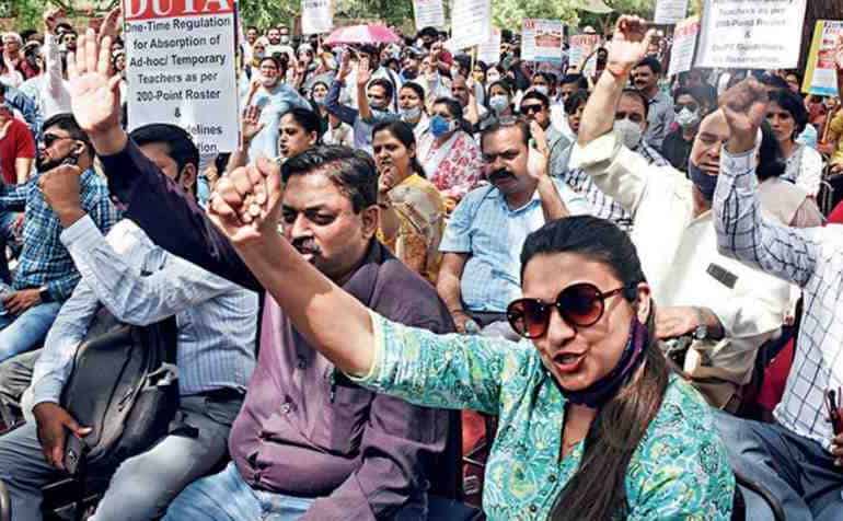Teachers and protesters raise their voice while holding placards demanding the regularisation of ad hoc and temporary faculty at Delhi University.
