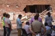 People gather outside a partially collapsed building at a Satya Niketan collapse site.