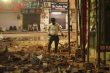 Scenes from the Satya Niketan PG collapse as a man clears the debris from the collapsed structure across the road.