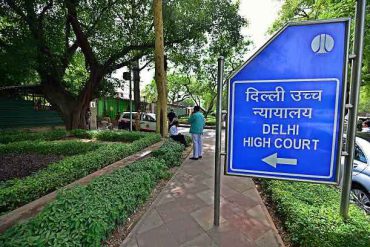 A sign pointing towards the Delhi High Court near its surrondings.